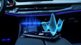 The inside of a car with a cellphone sitting on the middle armrest
