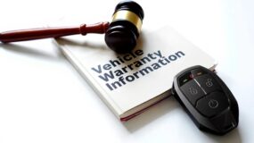 A gravel on top of a vehicle warrenty information pamphlet next to a remote car starter