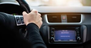 A close up on a man's hand on a steering wheel