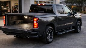 A black truck with a bed cover and its tailgate down